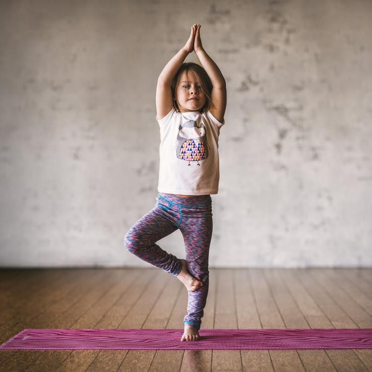 Girl in tree post on Gaiam Kids Pink Zebra Yoga Mat 3 mm