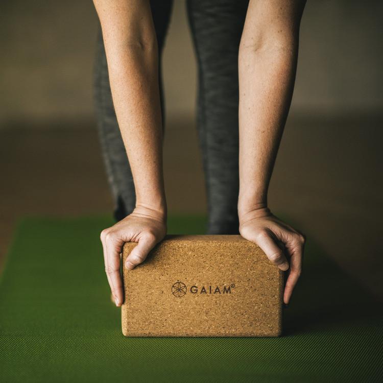 Woman using Gaiam Cork Yoga Brick